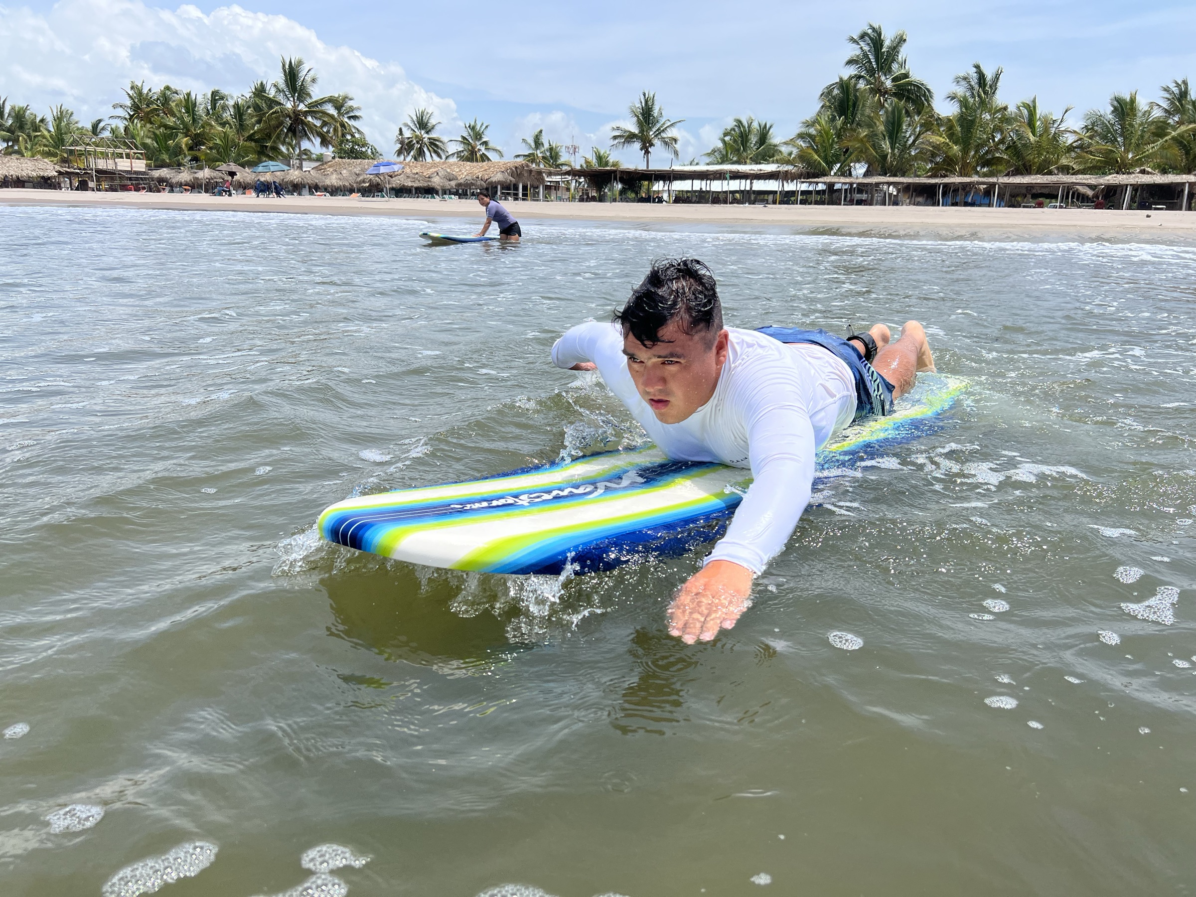 Alumno remando sobre una tabla de foam hacia la cámara
