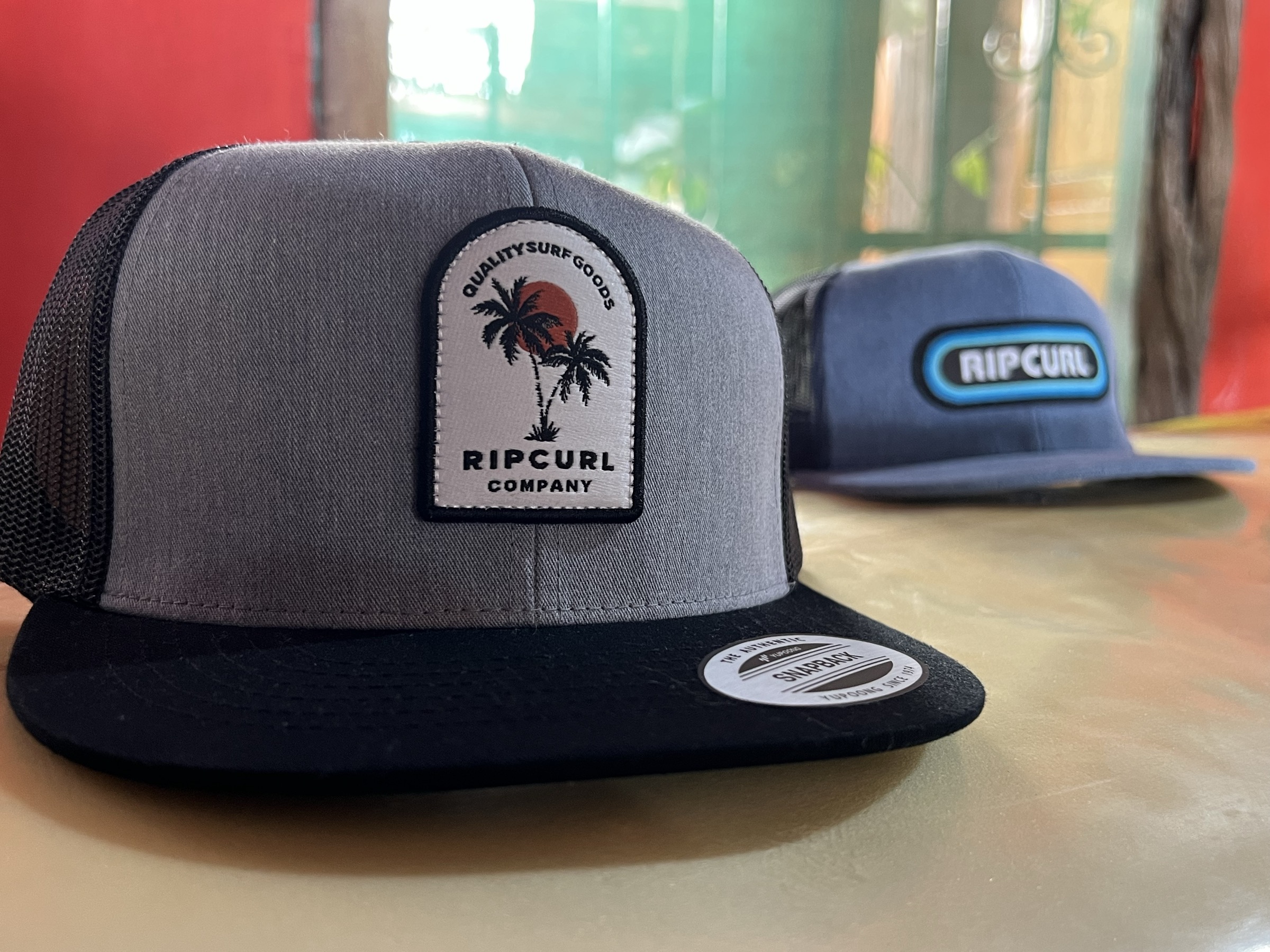 Gorras Rip Curl con etiqueta sobre el mostrador de la tienda