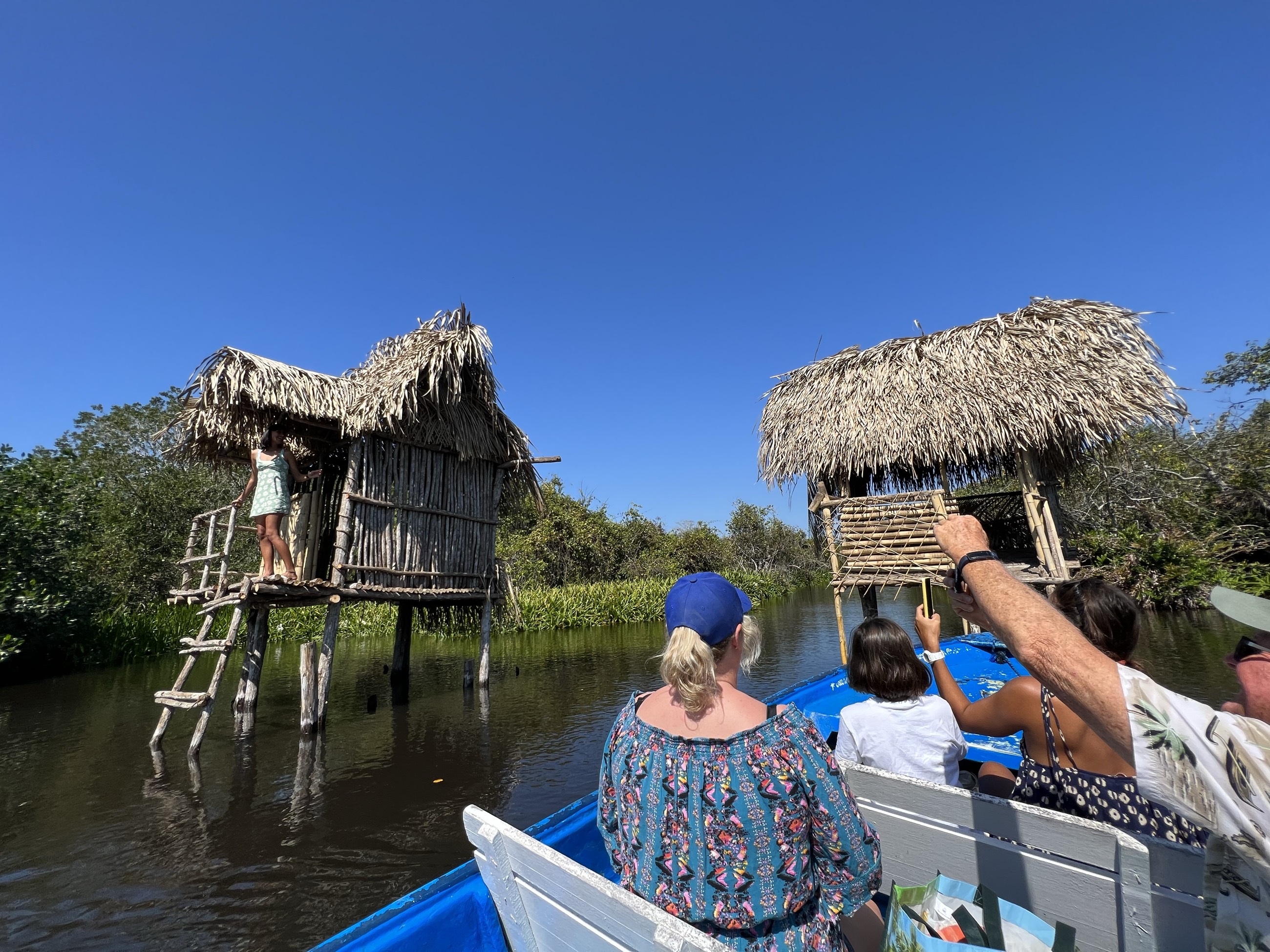 Lancha con pasajeros junto a las palapas sobre pilotes en el canal de La Tovara